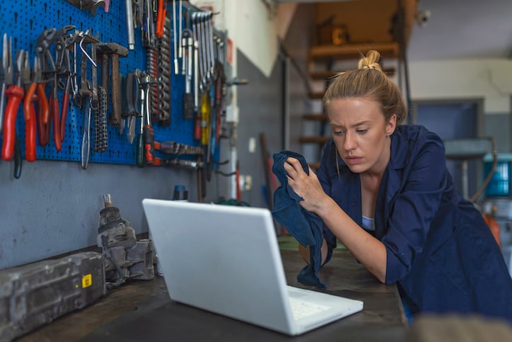 worker reading online about how preventive maintenance software can help streamline maintenance operations with preventive maintenance