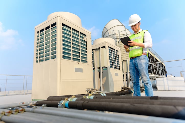 A person working in facility maintenance views reporting on her tablet while at a job site performing maintenance activities