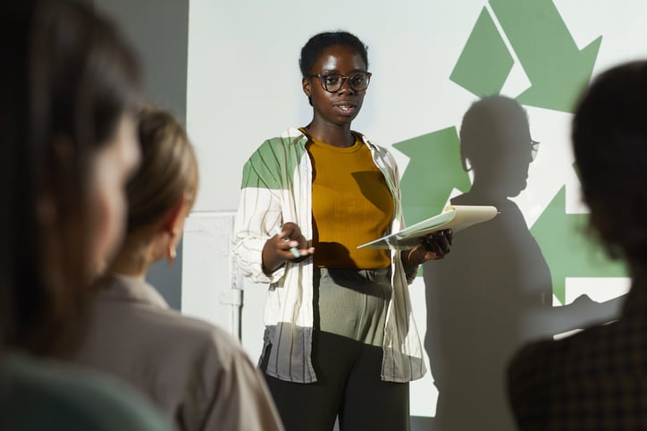 A woman explaing sustainable practices and new technologies to an audience of building managers