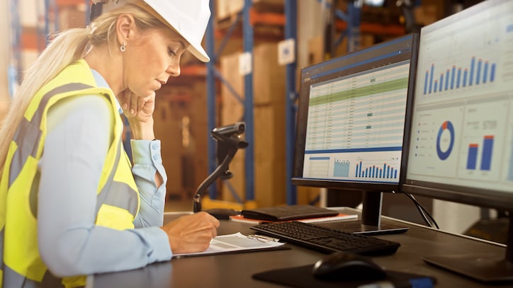 worker examining service history and job management in work order software for contractors in an effort to save time through streamlined project management