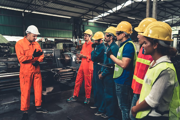 Maintenance technician staff looks on as a facilities maintenance manager gives direction on property maintenance tasks as part of regular maintenance operations